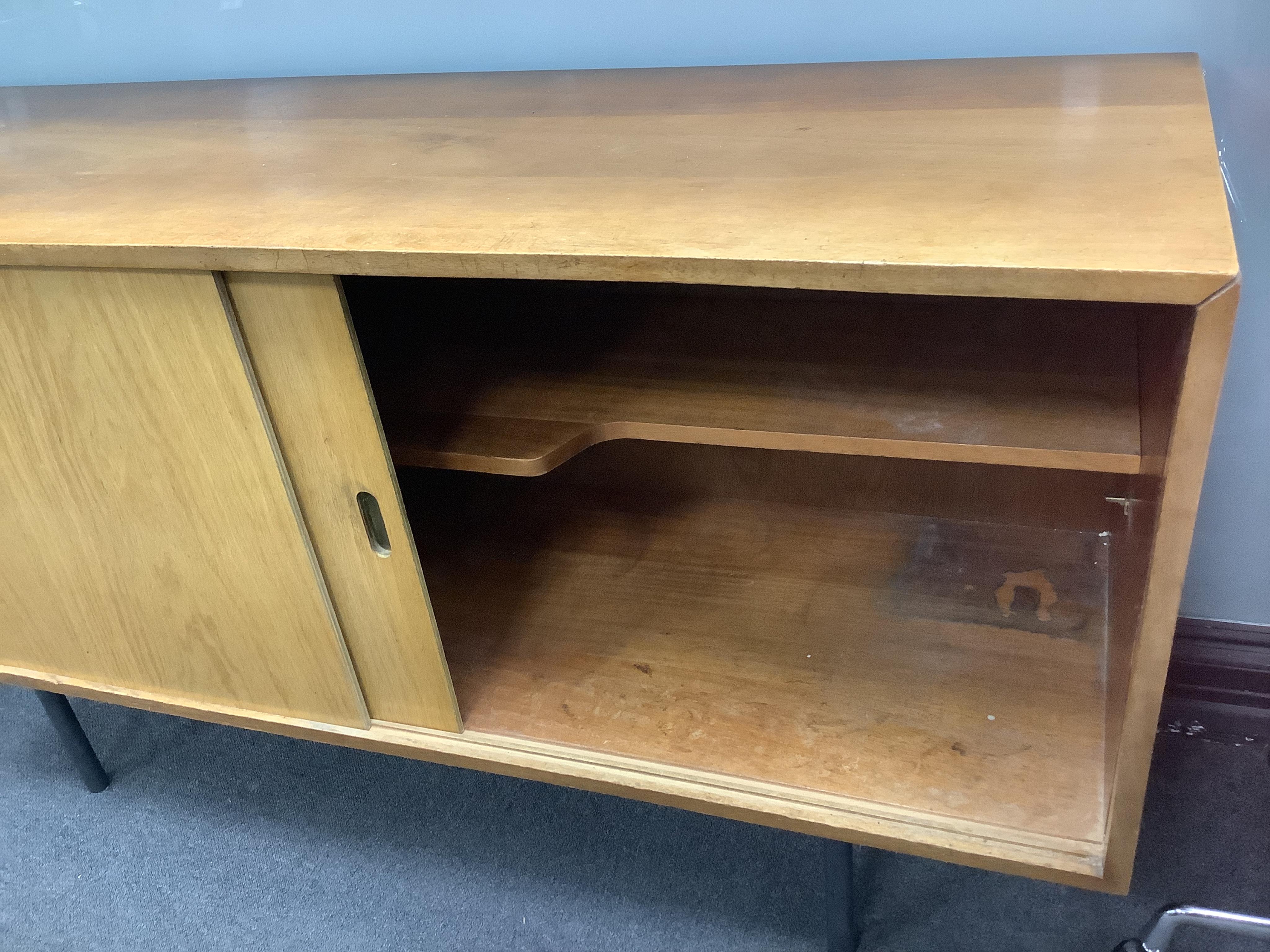 In the manner of Robin Day, a mid century walnut and plywood sideboard, width 137cm, depth 45cm, height 74cm. Condition - fair